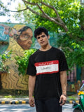 Black crew neck relaxed fit slogan t-shirt featuring a large red and white message box with 'HELLO I AM LOWKEY' text printed below chest area.